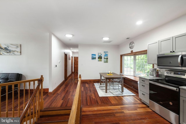 kitchen with stainless steel appliances, dark wood-type flooring, and gray cabinetry