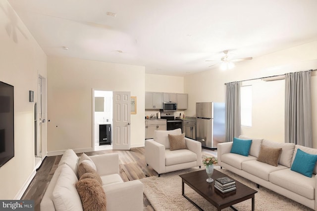 living room featuring ceiling fan and light wood-type flooring