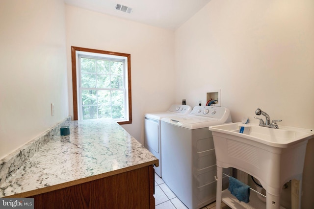 washroom featuring independent washer and dryer, light tile patterned floors, and sink