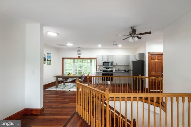 interior space with ceiling fan, sink, stainless steel appliances, and dark hardwood / wood-style floors