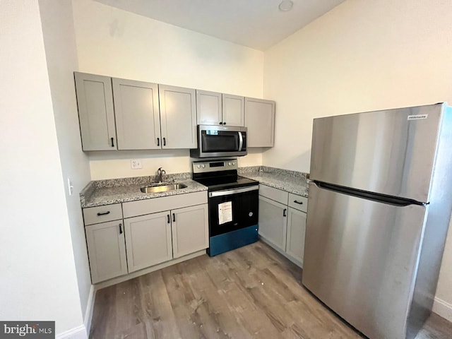 kitchen featuring gray cabinets, light hardwood / wood-style floors, sink, and appliances with stainless steel finishes