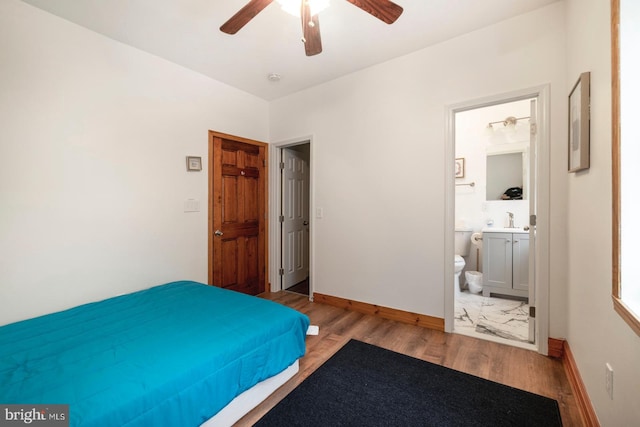 bedroom featuring ensuite bathroom, ceiling fan, light hardwood / wood-style floors, and sink