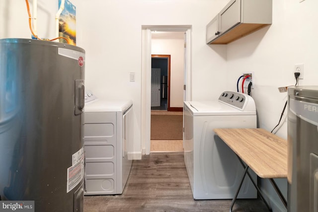 clothes washing area with cabinets, dark hardwood / wood-style flooring, separate washer and dryer, and water heater