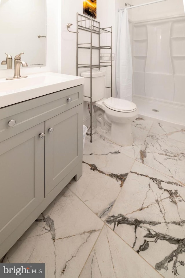 bathroom featuring vanity, curtained shower, and toilet