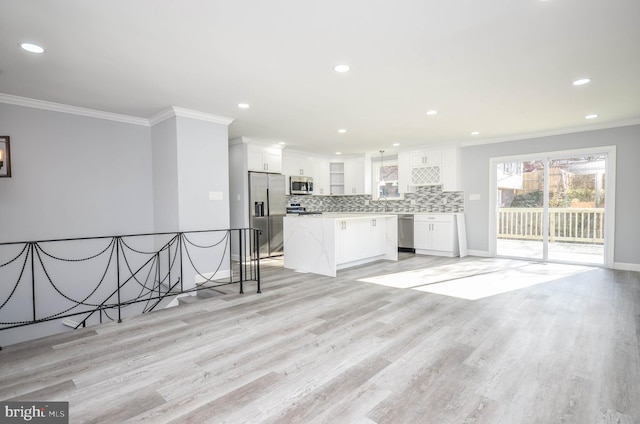 kitchen with a center island, light wood-type flooring, stainless steel appliances, and white cabinetry