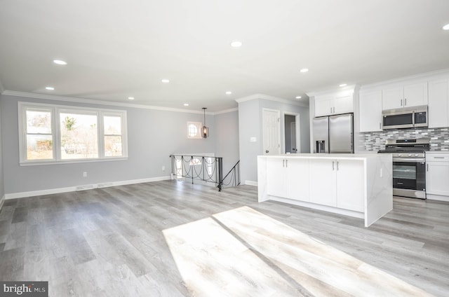 kitchen featuring white cabinetry, a center island, hanging light fixtures, stainless steel appliances, and light hardwood / wood-style flooring