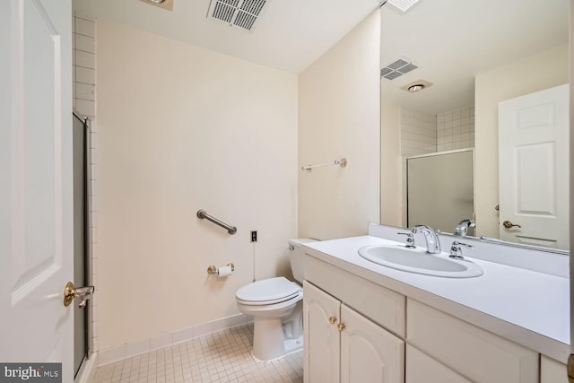 bathroom featuring toilet, vanity, tile patterned floors, and a shower with shower door