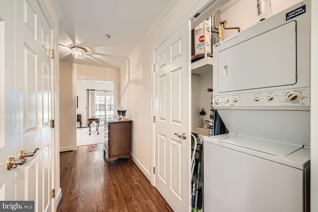 laundry area with dark hardwood / wood-style flooring, crown molding, and stacked washer and clothes dryer