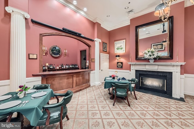 interior space with bar area, a brick fireplace, and crown molding