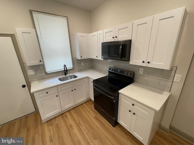 kitchen with sink, white cabinets, and black appliances