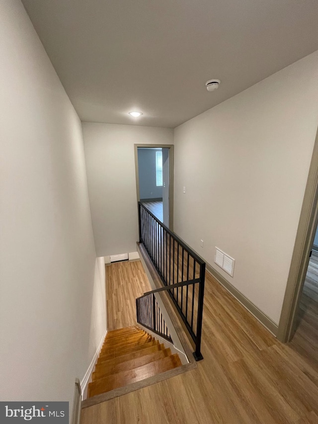 staircase with hardwood / wood-style flooring