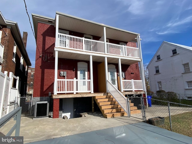 view of front of home with central AC unit and a balcony