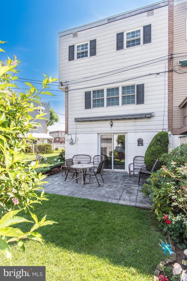 rear view of property with a patio area and a lawn