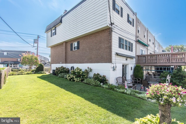 view of home's exterior featuring a lawn and a wooden deck