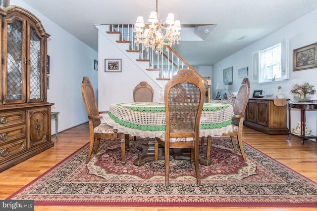 dining space featuring a chandelier, hardwood / wood-style floors, and a textured ceiling