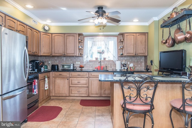 kitchen featuring sink, stainless steel appliances, kitchen peninsula, a kitchen bar, and ornamental molding