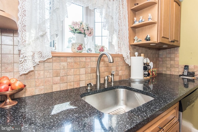 kitchen featuring tasteful backsplash, sink, dark stone counters, and stainless steel dishwasher