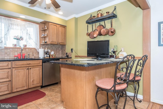 kitchen with dishwasher, a kitchen breakfast bar, sink, crown molding, and tasteful backsplash