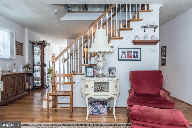 stairway featuring wood-type flooring and a textured ceiling