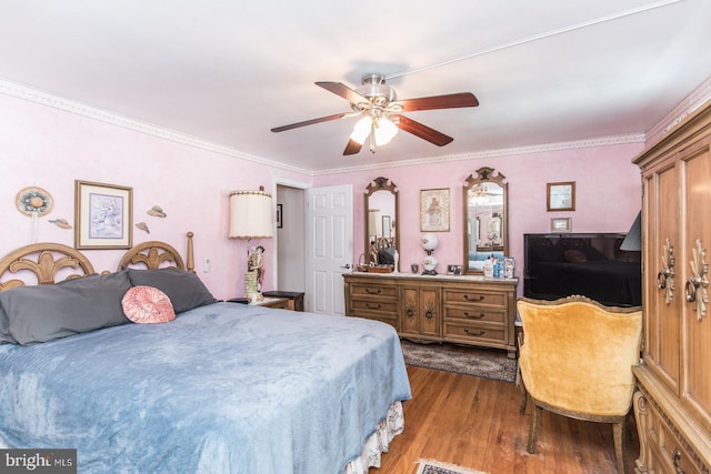 bedroom with ceiling fan, hardwood / wood-style floors, and crown molding