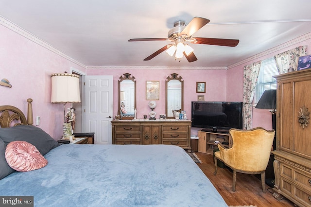 bedroom featuring dark hardwood / wood-style floors, ceiling fan, and crown molding