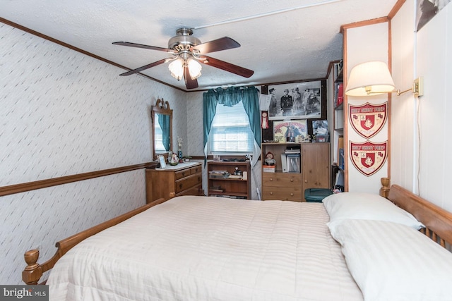 bedroom featuring ceiling fan, a textured ceiling, and ornamental molding