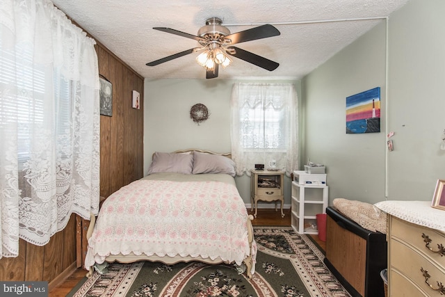 bedroom featuring hardwood / wood-style floors, a textured ceiling, and ceiling fan