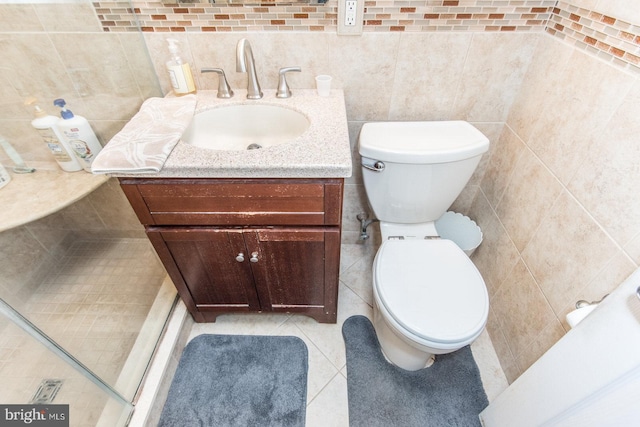 bathroom featuring vanity, tile walls, and toilet