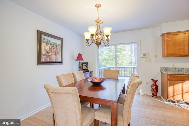 dining area featuring light hardwood / wood-style flooring and an inviting chandelier