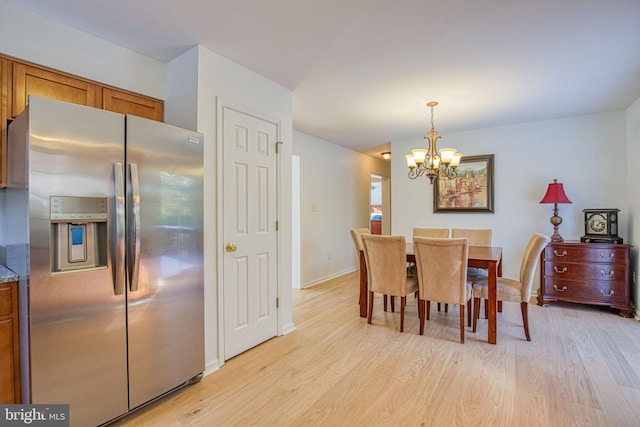 dining room with a chandelier and light wood-type flooring