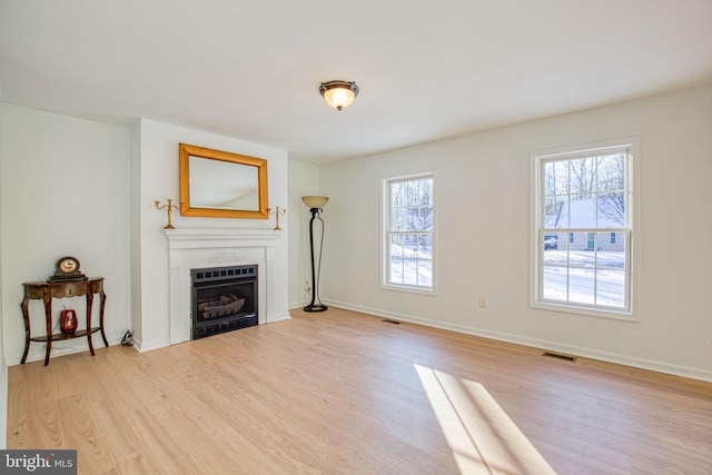 65 Francis, Montross, VA 22520 - unfurnished living room with light wood-style flooring, a fireplace, and baseboards
