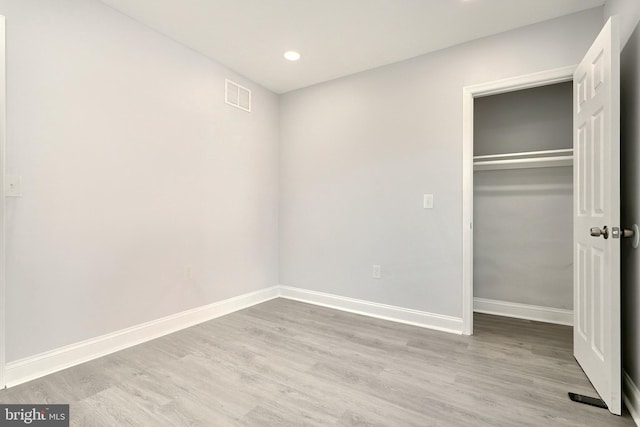 unfurnished bedroom with a closet and light hardwood / wood-style flooring