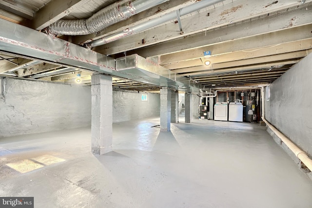 basement featuring washing machine and dryer and electric water heater