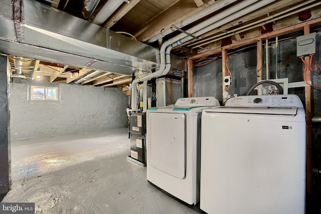 basement featuring heating unit and washing machine and clothes dryer