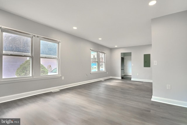 unfurnished room featuring electric panel and dark wood-type flooring