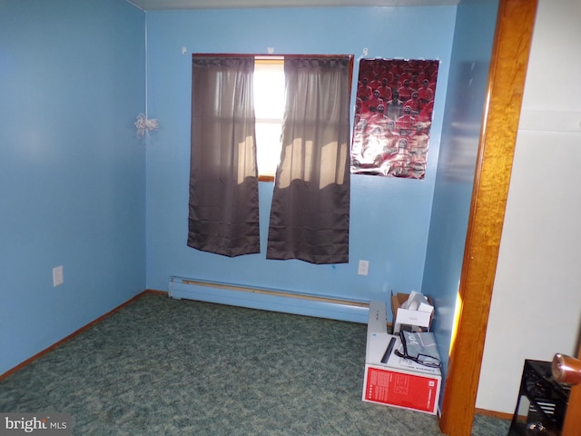 carpeted spare room featuring a baseboard heating unit