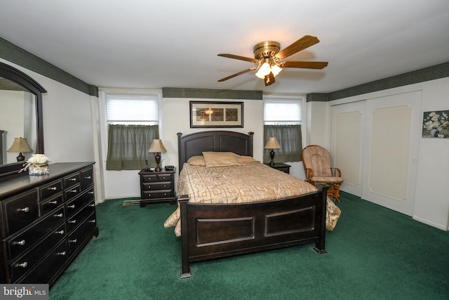 bedroom with dark colored carpet, ceiling fan, a closet, and multiple windows