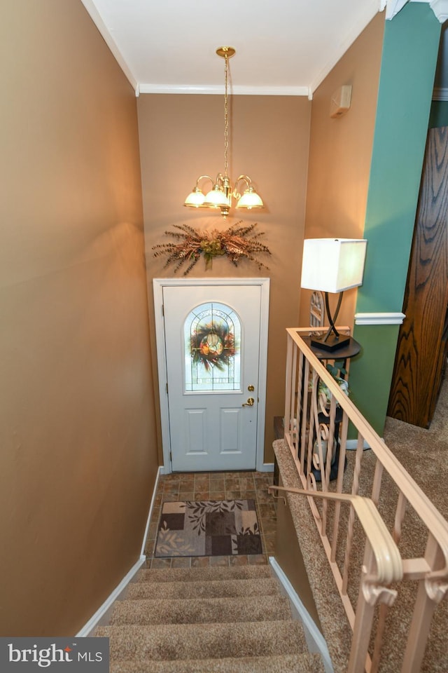 carpeted entrance foyer with a chandelier and crown molding