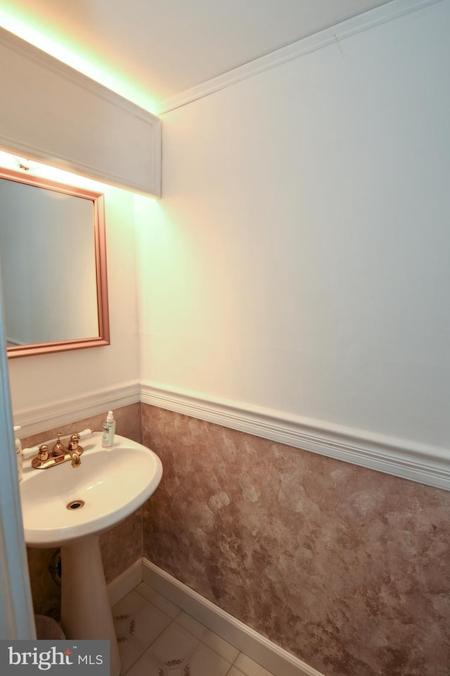 bathroom featuring tile patterned flooring, sink, and crown molding