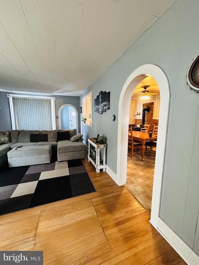 living room with wood-type flooring, a textured ceiling, and ceiling fan