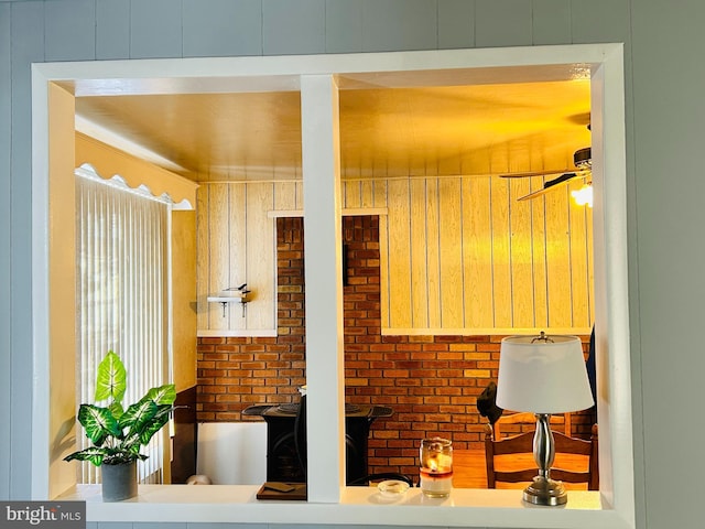 kitchen with ceiling fan and brick wall