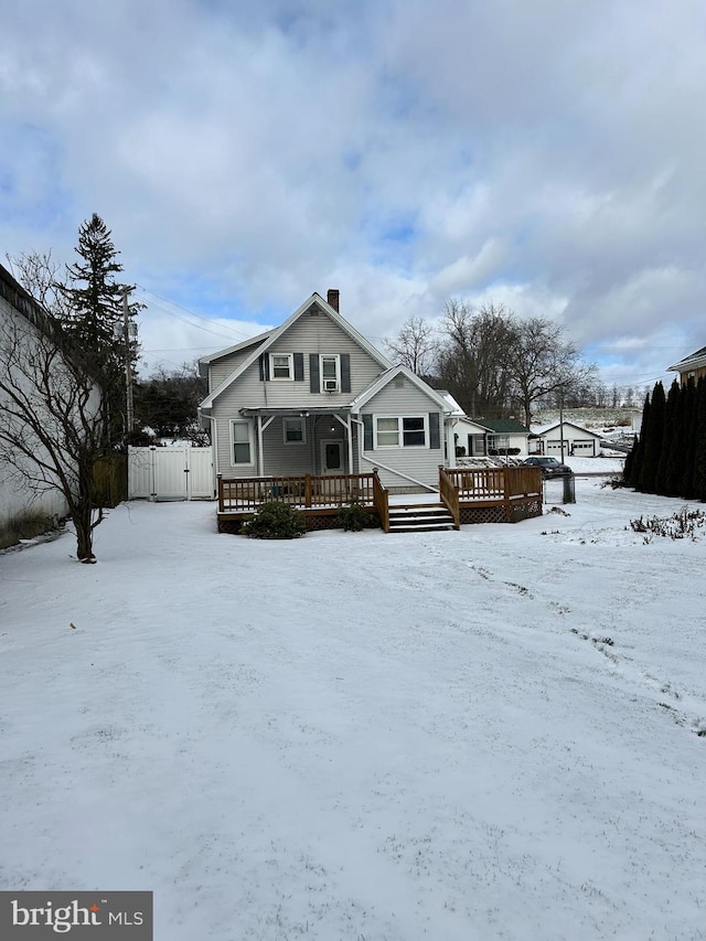 snow covered house with a deck