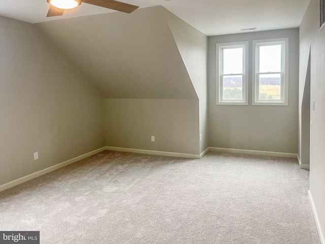 additional living space featuring ceiling fan, light colored carpet, and vaulted ceiling