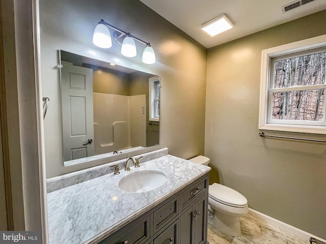 bathroom featuring vanity, toilet, and walk in shower