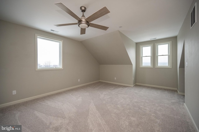 additional living space featuring plenty of natural light, ceiling fan, light carpet, and vaulted ceiling