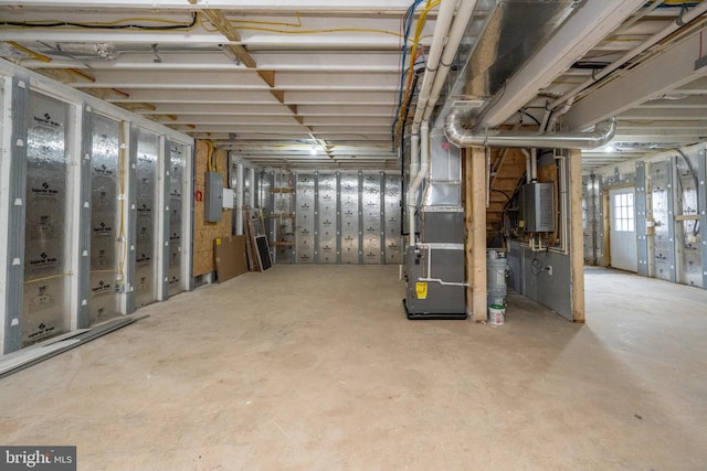 basement featuring heating unit, electric panel, and water heater