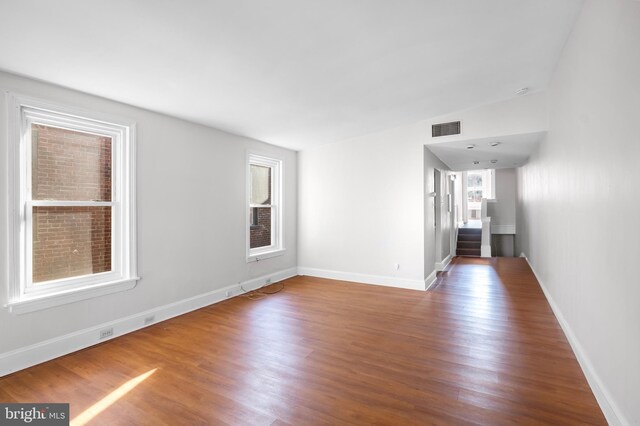 unfurnished room with hardwood / wood-style flooring and vaulted ceiling