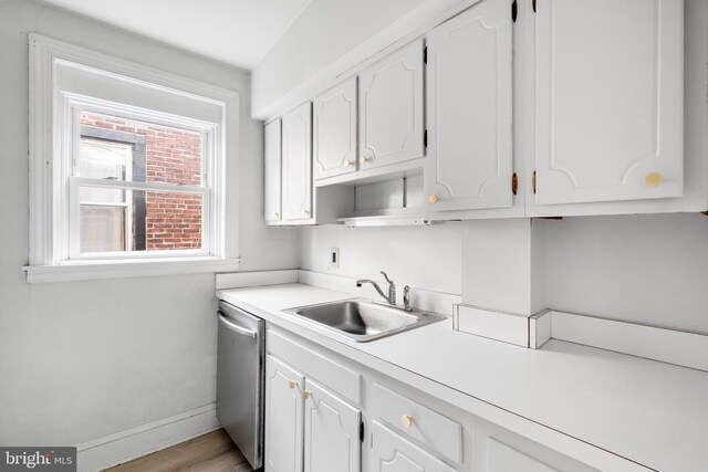 kitchen featuring white cabinets, dishwasher, light wood-type flooring, and sink