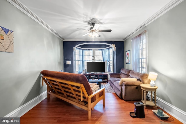 living room featuring hardwood / wood-style flooring, a wealth of natural light, crown molding, and ceiling fan