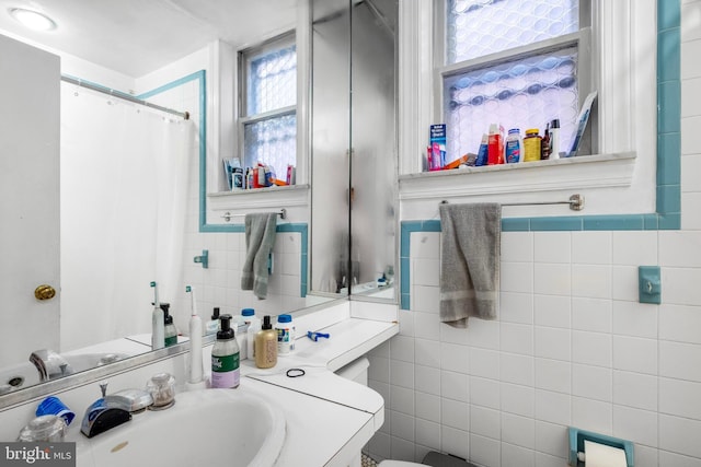 bathroom with vanity and tile walls